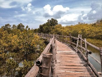 View of wooden footbridge against trees