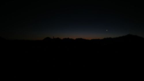 Silhouette landscape against clear sky at night