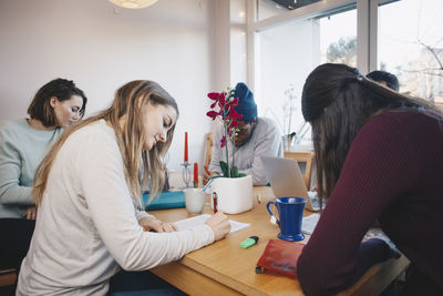 Young roommates studying together in college dorm room