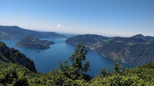 High angle view of lake and mountains against blue sky