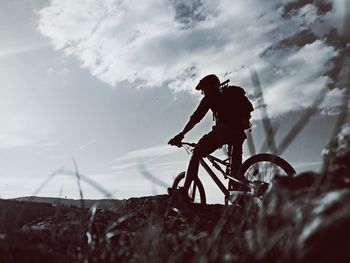 Man cycling against sky on sunny day