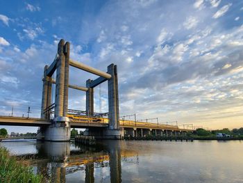 

trainbridge hoge gouwebrug over gouwekanaal near gouda with reflections in the water before sunset
