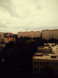 View of cityscape against cloudy sky