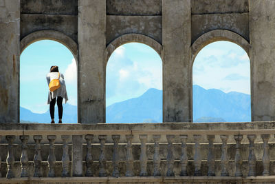 Man looking at arch bridge