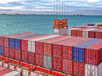 Industrial port crane lift up loading export containers box onboard from truck at port of thailand.