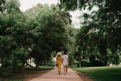 Rear view of couple walking in park