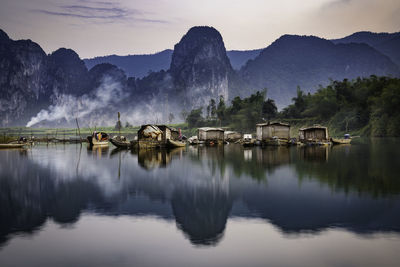 Boathouses on lake by mountains