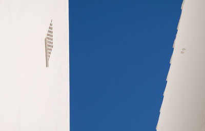 Low angle view of buildings against clear blue sky