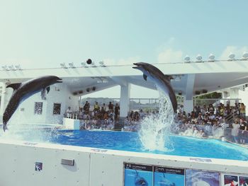 People swimming in pool against sky