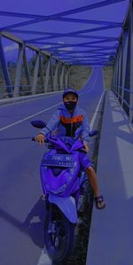 Portrait of man riding bicycle on bridge