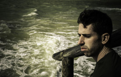 Close-up of young man looking at sea