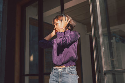 Young woman looking through window