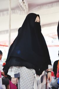 Rear view of woman standing against the wall
