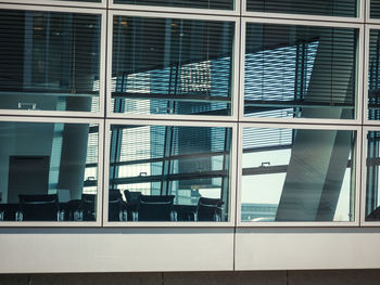 Office chairs seen through glass window in building