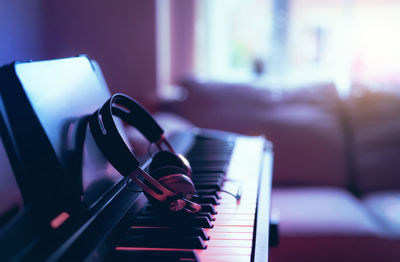 Close-up of piano with headphones at home