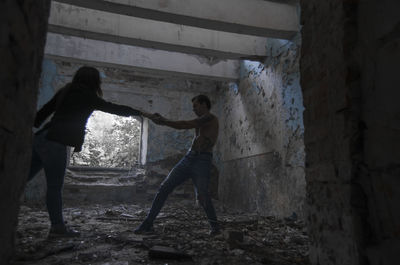 Side view of people standing in abandoned building