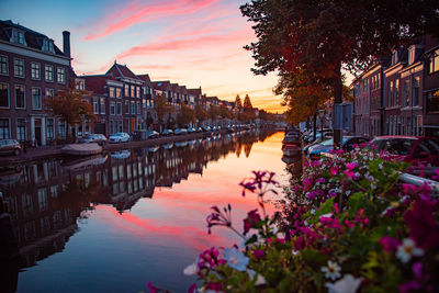 Canal amidst buildings against sky during sunset