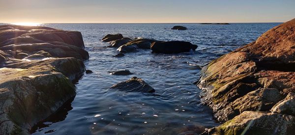 Rocks on sea shore against sky