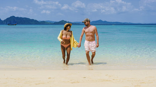 Rear view of woman standing at beach