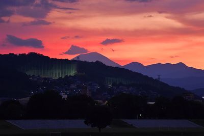 Scenic view of silhouette mountains against orange sky