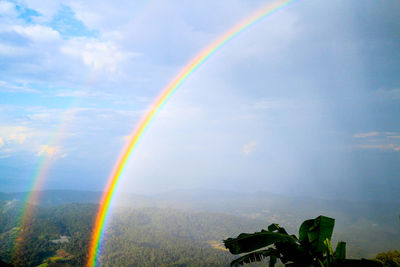 Rainbow over landscape against sky