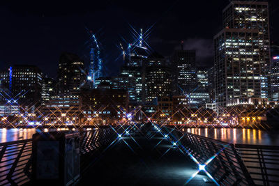 Illuminated boardwalk and cityscape at night