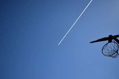 Low angle view of vapor trail against clear blue sky