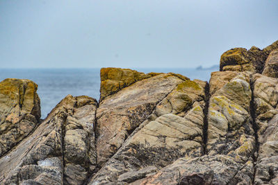 Rock formations by sea against sky