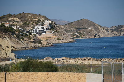 Scenic view of sea and mountains against clear sky
