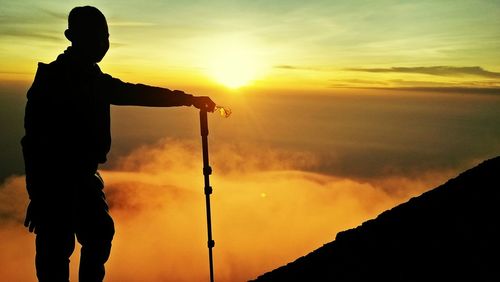 Silhouette man standing against sky during sunset