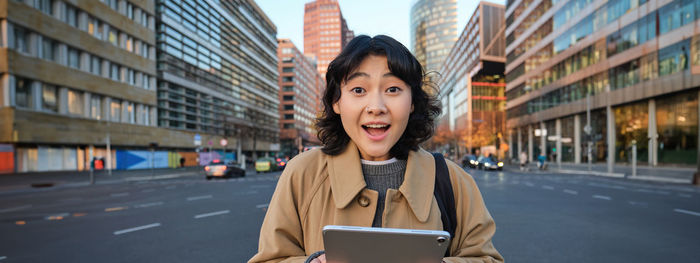 Young woman using mobile phone in city