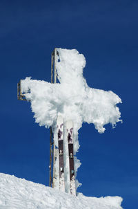 Snow covered built structure against blue sky