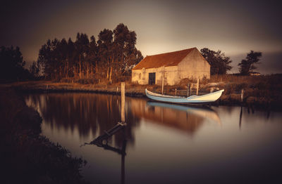 Boats in lake by buildings against sky