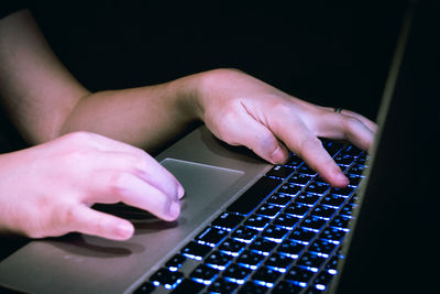 Midsection of person using laptop typing keyboard