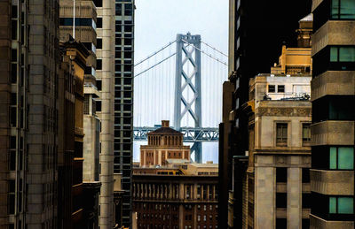 Buildings against bay bridge in city