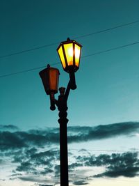 Low angle view of illuminated street light against sky