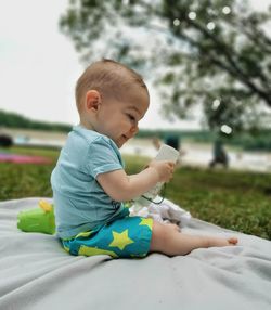 Side view of boy playing with glass