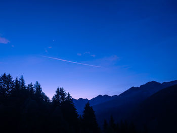 Scenic view of silhouette mountains against blue sky