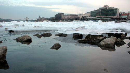 Rocks in sea against sky during winter