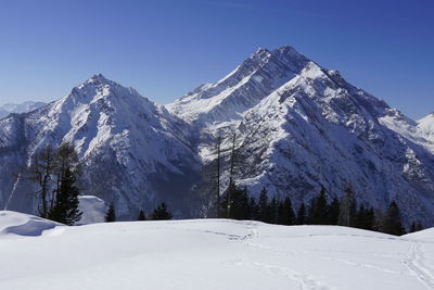 Scenic view of snow covered mountains against clear sky