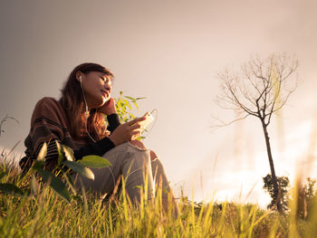 Young woman sitting on field