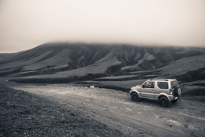 Car on mountain road against sky