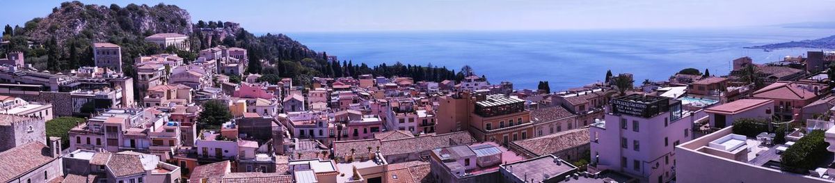 High angle view of townscape by sea against sky