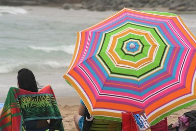 Low section of people on multi colored umbrellas