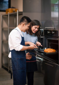 Friends standing on table at kitchen