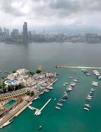 High angle view of city by sea against sky