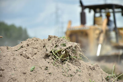 A pile of soil isolated with blurred image of tractor working in a field