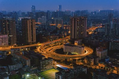 High angle view of illuminated street amidst buildings in city