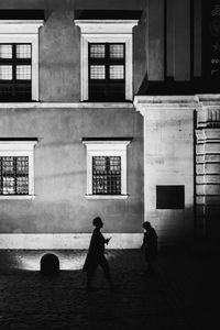 Rear view of people walking in front of building