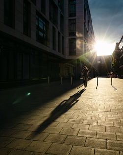 People walking on footpath by buildings in city